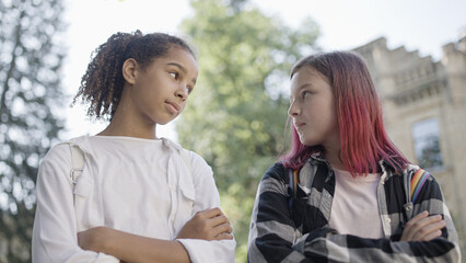 Two girls looking at each other with hostility, bullying, socialization problem at school