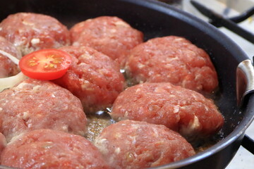 Cooking chops in a frying pan.