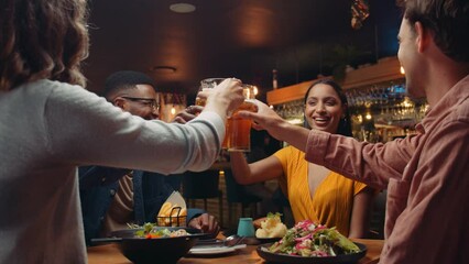 Diverse group of friends out for dinner making a toast - Powered by Adobe