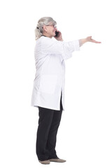 female doctor with a smartphone pointing at an ad on a white wall .