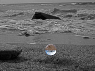 Fototapeta na wymiar Glaskugel am Meer, Spiegelung Schwarz Weiß 