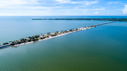 Fototapeta na wymiar Aerial Drone of the Causeway Bridge Before Hurricane Ian in Sanibel, Florida with the Bay and a Preserve in the Foreground and the Gulf of Mexico in the Background Featuring a Blue Sky and Blue Water