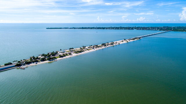 Aerial Drone of the Causeway Bridge Before Hurricane Ian in Sanibel, Florida with the Bay and a Preserve in the Foreground and the Gulf of Mexico in the Background Featuring a Blue Sky and Blue Water