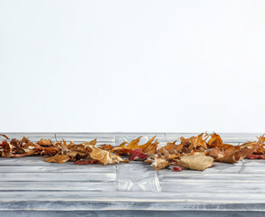 Desk of free space cover of autumn leaves and wall background. 