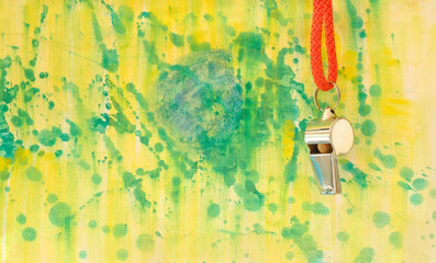 Whistle of soccer referee or trainer on grungy background with brazilian national colours. Great...