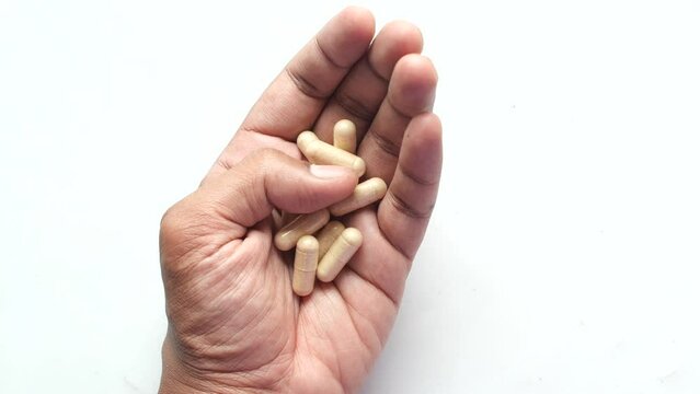 top view of herbal medicine capsule on hand on white background 