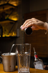 A bartender prepares a cocktail at the restaurant bar
