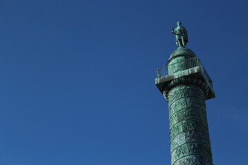 Top of Vendôme Column including Napoleon statue against a clear blue sky. A French landmark in the 1st arrondissement of Paris - obrazy, fototapety, plakaty
