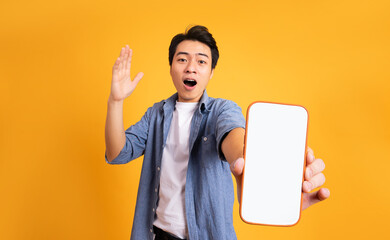image of asian man holding phone, isolated on yellow background