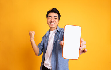 image of asian man holding phone, isolated on yellow background