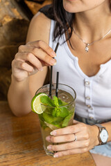 The girl tastes a cocktail at the restaurant bar
