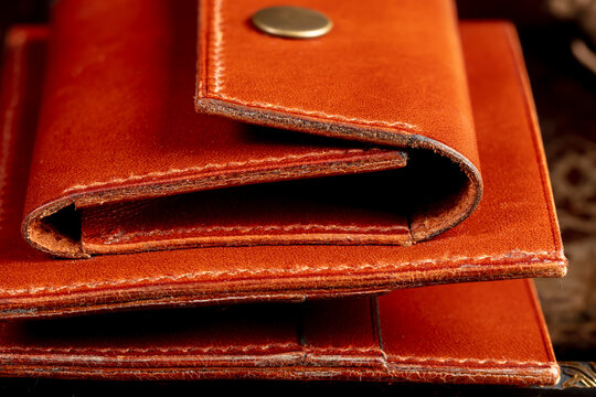 Part of a brown leather wallet or case with stitching.
