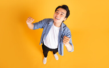 image of asian man posing on a yellow background - Powered by Adobe
