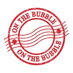 ON THE BUBBLE, text written on red postal stamp.