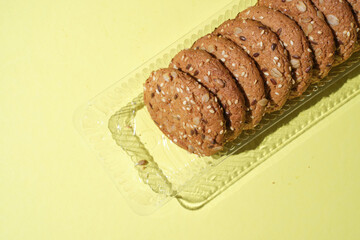Dietary oatmeal cookies with  seeds on yellow background.