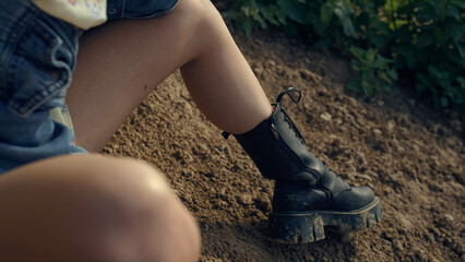 Upset woman sitting sand shore in sunglasses close up. Model posing on beach.