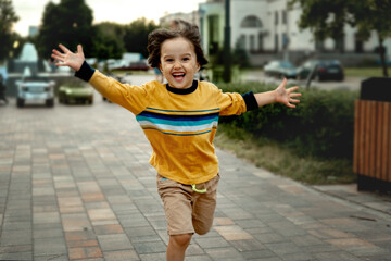 A three-year-old boy with long dark hair of Asian appearance runs towards his parents with his arms wide apart