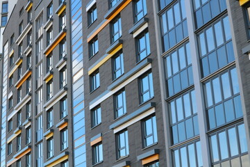 Fototapeta premium Windows of a multi-storey residential building. Modern urban abstract background.