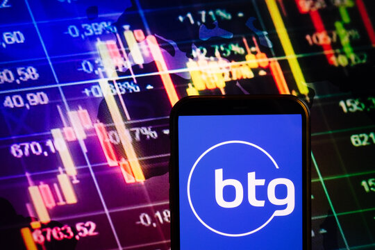 KONSKIE, POLAND - September 10, 2022: Smartphone displaying logo of BTG Pactual company on stock exchange chart background