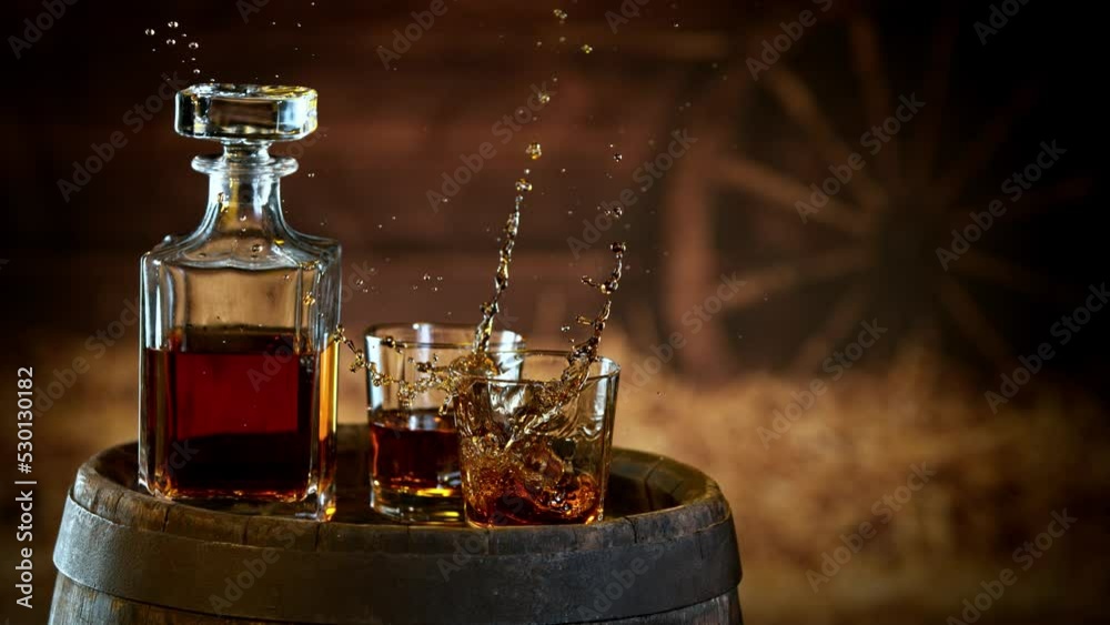 Poster super slow motion of falling ice cube into whiskey. speed ramp effect. filmed on high speed cinema c
