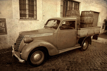 Antique van for freight transport, two large wooden barrels in the trailer, sepia photo, antiqued effect.