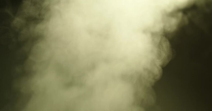 Abstraction, white smoke, steam, rises up on a dark background. Close-up.