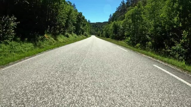 First person view of a nordic road, Norway, lush green contryside
