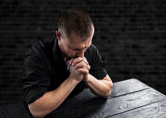 A Christ man prayers on dark background. Christian religion concept