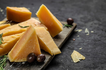 Pieces of parmigiano reggiano or parmesan cheese, Hard cheese, olives, rosemary. place for text, top view