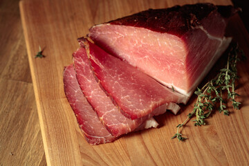 Dry-cured pork with thyme on a cutting board.