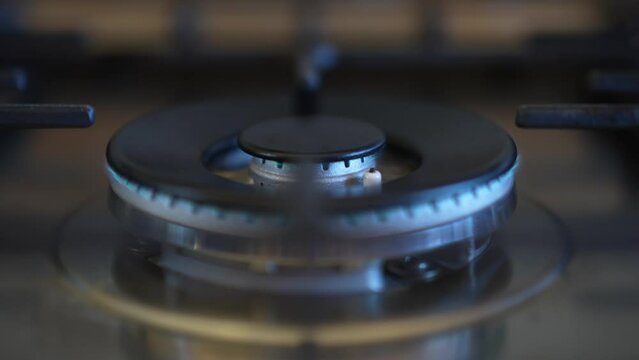 Closeup of turning off the gas stove to save money due to high price of natural gas in Europe.