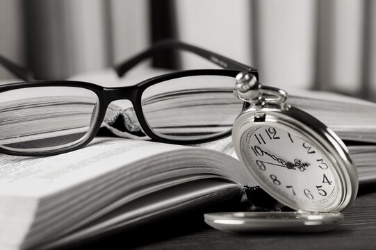 Vintage pocket watch and book on the desk