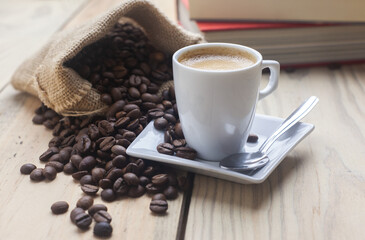 Taza de cafe junto a libros de texto sobre la mesa