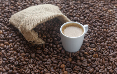 Taza de café por la mañana sobre granos de café tostado