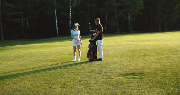 Golfer and caddy walking towards the field. High quality 4k footage