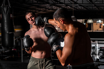 High quality photography. Two men boxing in a gym. A Caucasian man and a Latino man boxing in a...