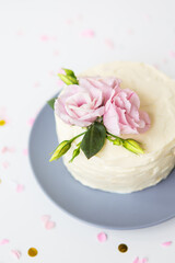 Fototapeta na wymiar Very beautiful small white cake decorated with fresh eustoma flowers. Holiday concept.