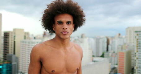 Fototapeta na wymiar Shirtless young handsome mixed race african man standing on top of rooftop