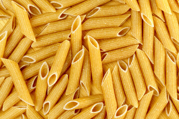 Whole grain penne pasta from durum wheat. Top view. Texture