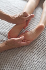 Masseur hands gives foot massage to a child. Sensual touching 