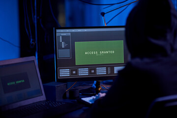 cybercrime, hacking and technology concept - close up of hacker in dark room breaking security system or using computer virus program for cyber attack