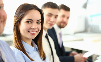 Portrait of pretty young business woman smiling at meeting with colleagues