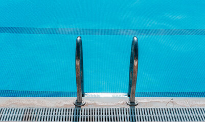 Close-up, metallic ladder on the edge of the pool