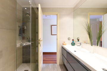 wc in white tones with frameless mirror that covers the entire wall, elongated resin sink and chest of drawers