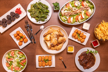 Recipes of typical Spanish dishes and tapas with croquettes of various flavors, salad with tuna and tomato, fried padron peppers, chopped chicken and rice blood sausage