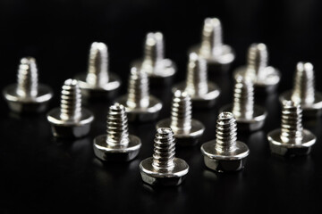 A group of Small bolts for computer equipment and computer assembly on black background