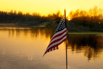 American flag on the sunset lake background. USA holiday concept