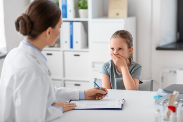 medicine, healthcare and pediatry concept - female doctor or pediatrician with clipboard and coughing little girl patient on medical exam at clinic