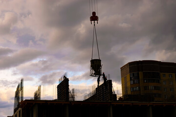 builders pour concrete on the construction site. silhouettes