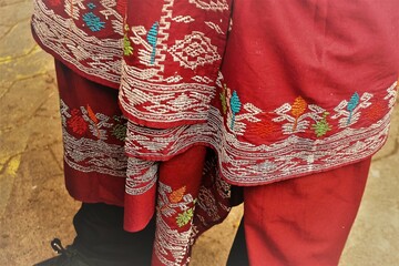 Traditionelle rote Tunika und Hose mit weiß-buntem Muster von indonesischem Mann 